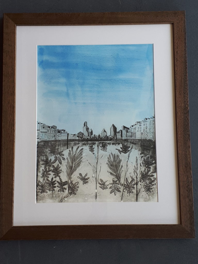 Gelatin print of leaves and grass seedheads in the foreground of a perspective drawing of a city skyline against a watercolour blue background. Framed in Tasmanian Oak.